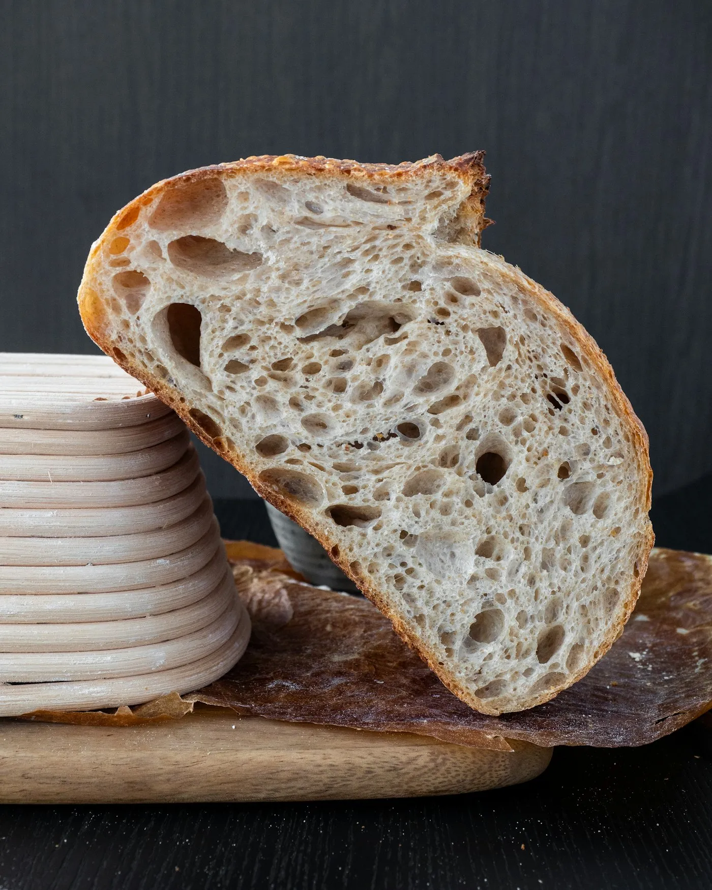 A round loaf of bread with a dark crust on a wooden chopping board