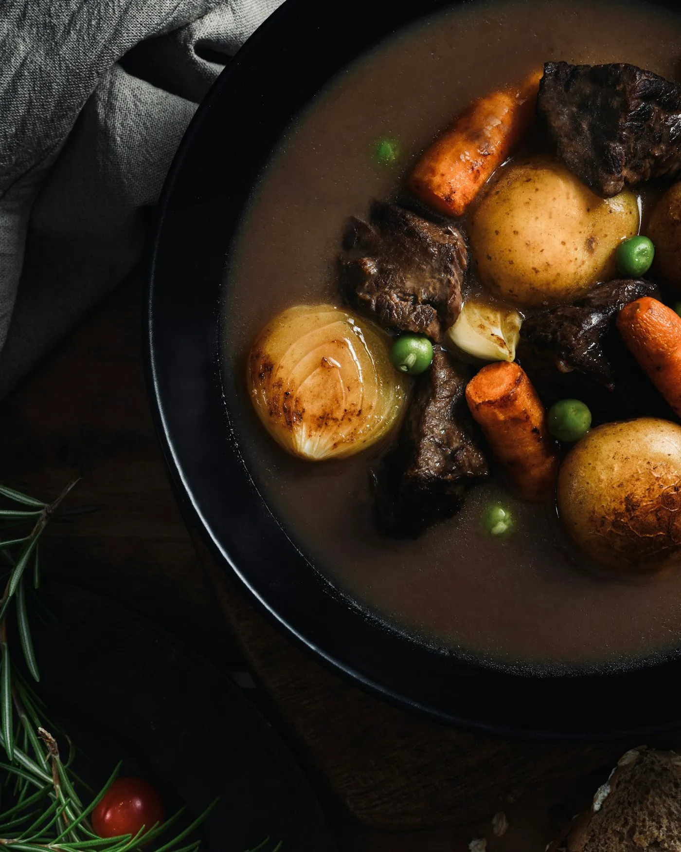 A bowl of dark stew with potatoes, carrots and pieces of meat