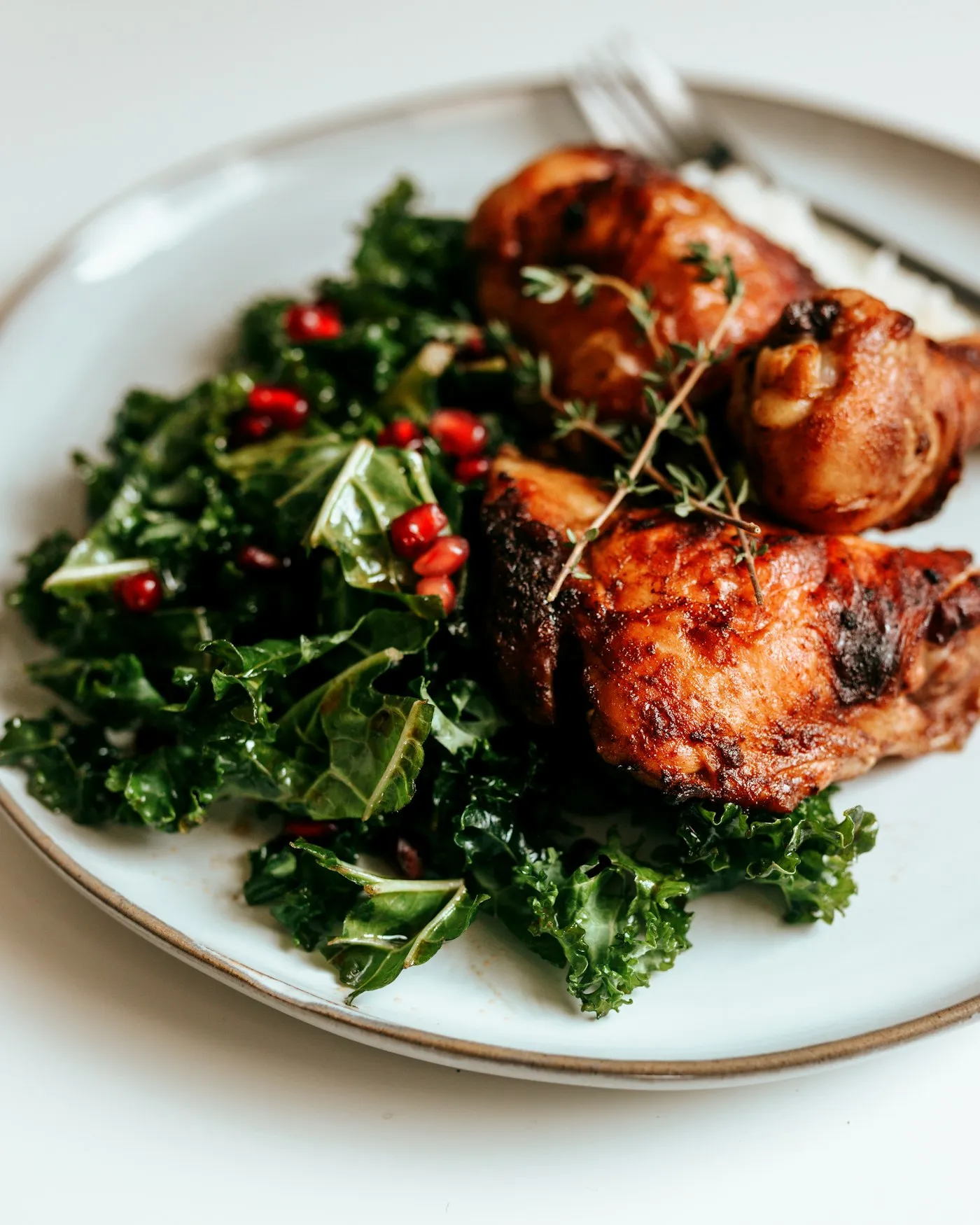 Cooked chicken with green vegetables on a white ceramic plate
