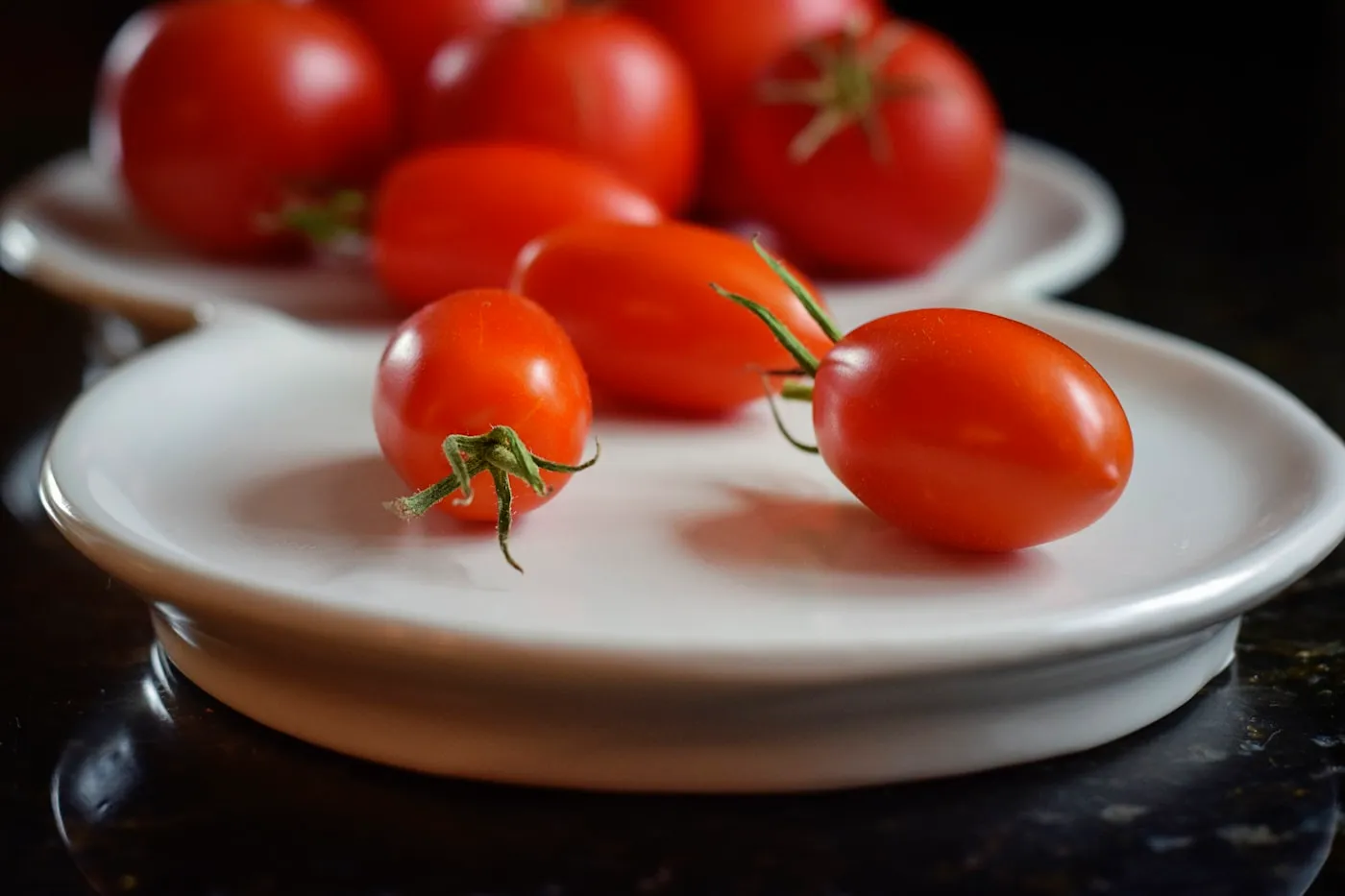 Ripe tomatoes on a white ceramic plate
